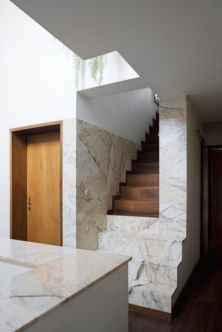 A modern, newly built house with a flight of marble and wood stairs