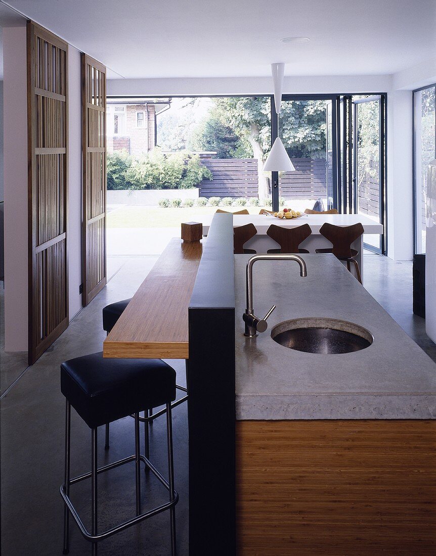 Freistehender Küchenblock mit Steinplatte und Spüle im offenen Wohnraum