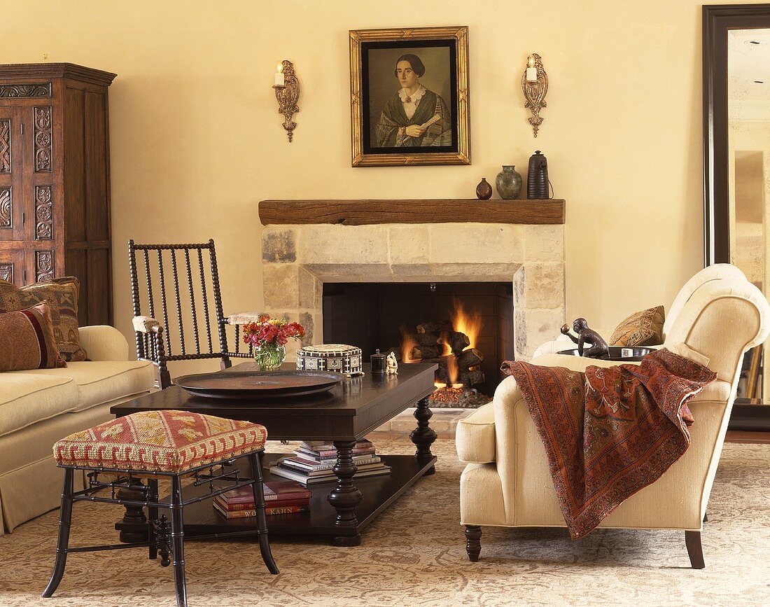Cremefarbene Polstermöbel und ein Couchtisch aus Holz vor dem Kamin in einem Wohnzimmer