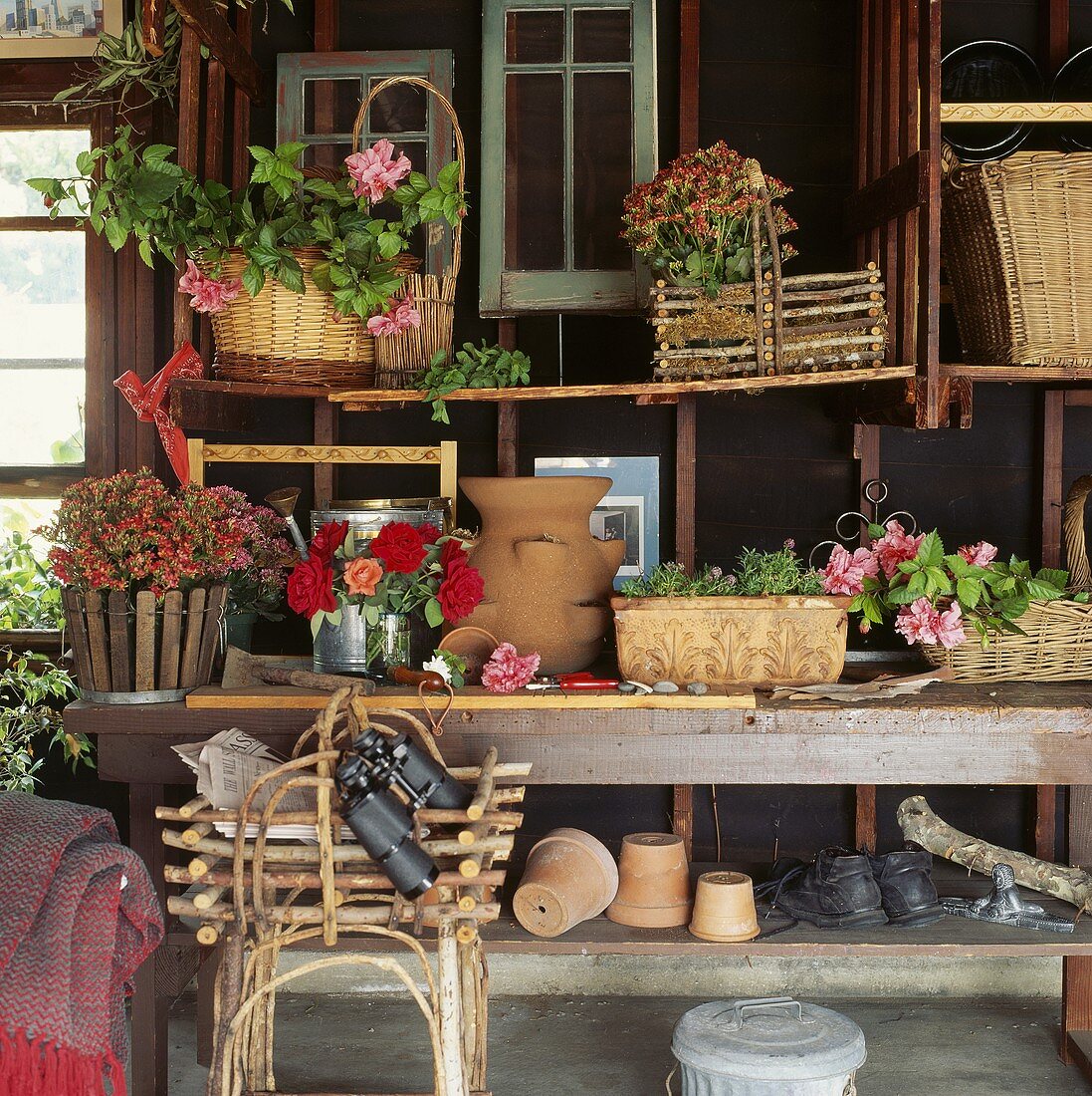 Körbe und Blumentöpfe auf den Regalen in Gartenhaus