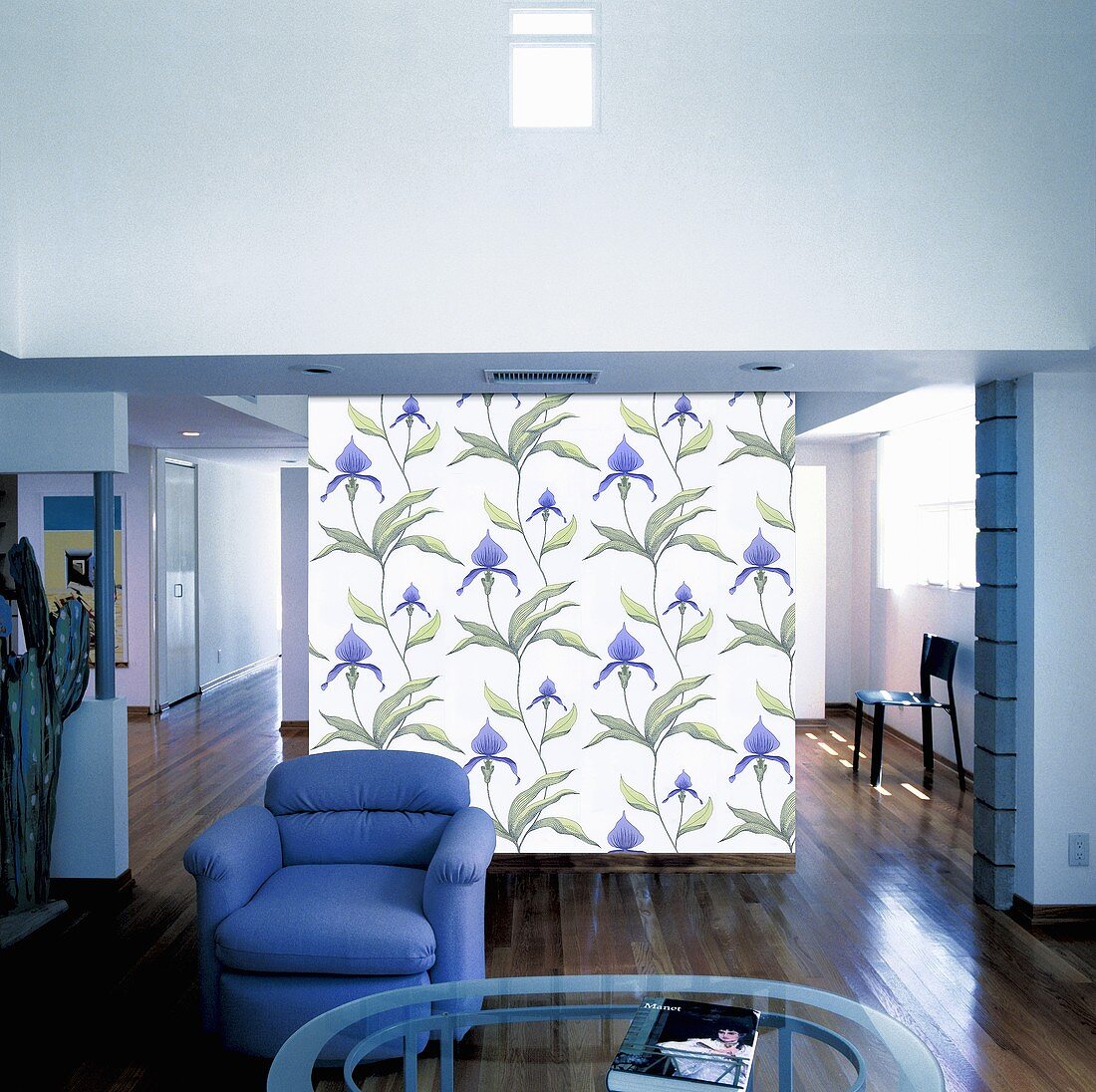 Leinwand-Tapete als Raumteiler hinter einem blauen Sessel