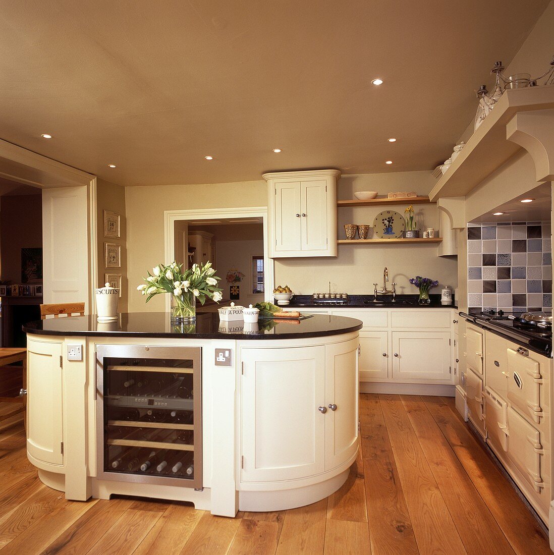 Kücheninsel mit integriertem Weinkühler in einer cremefarbenen Küche mit Holzboden