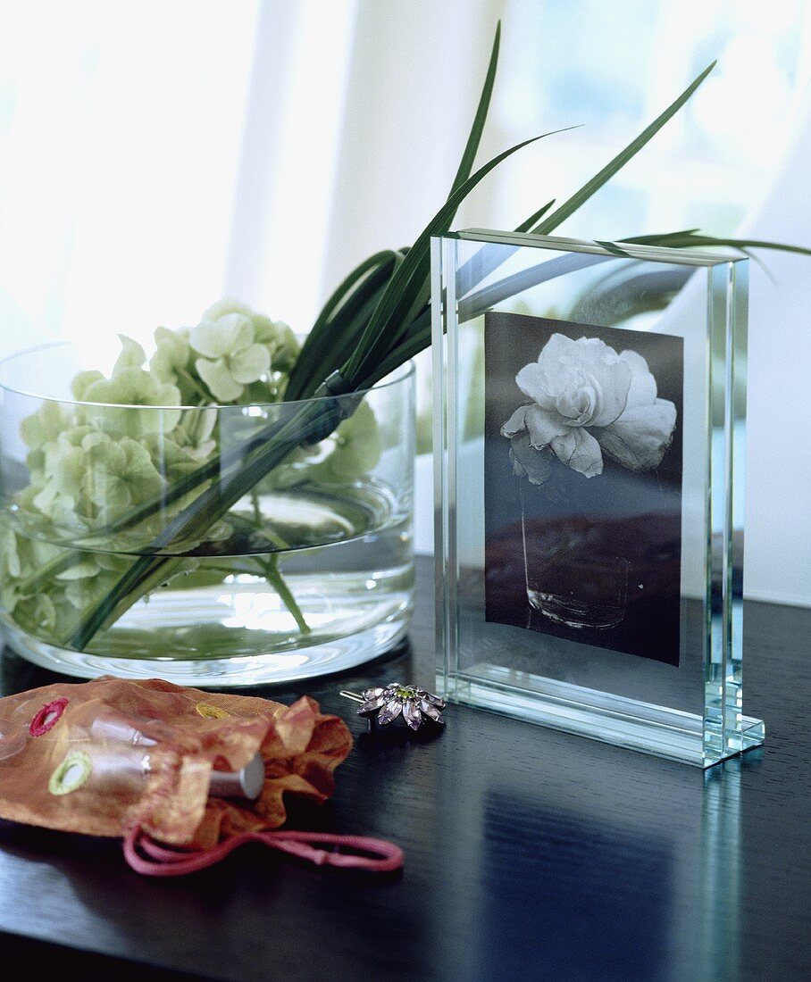 Bilderrahmen neben einer Glasschale mit Blumen