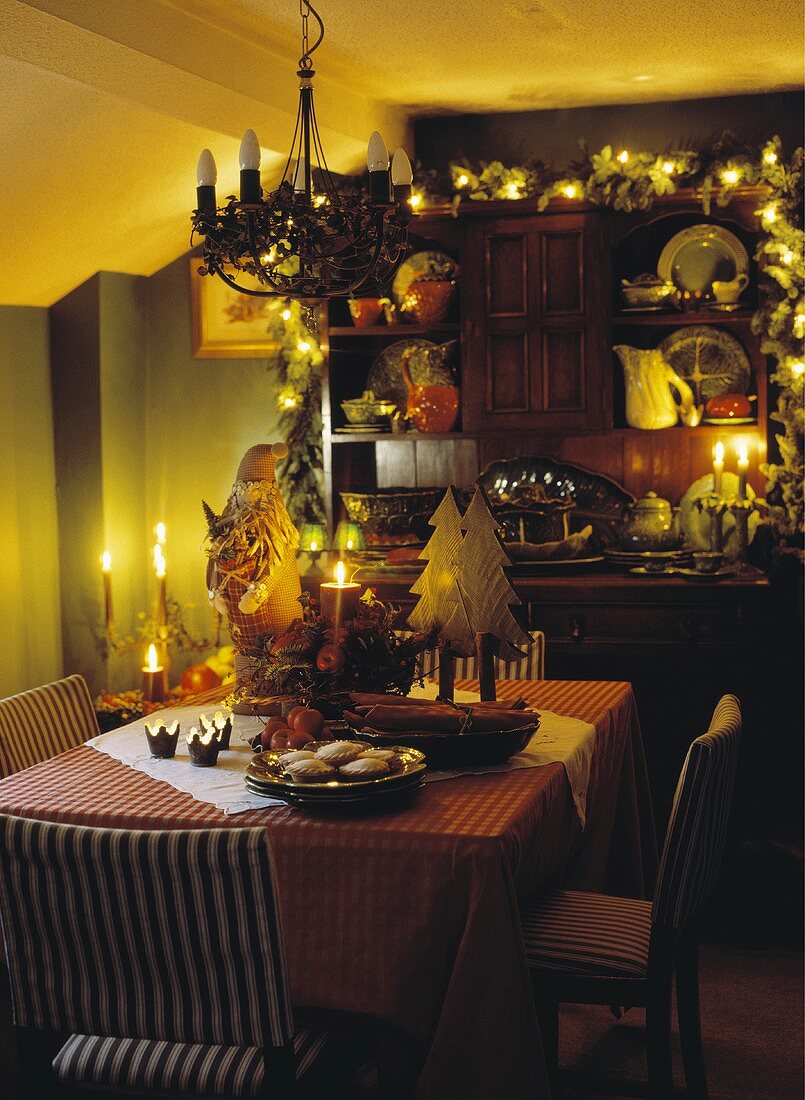 Lichterketten und Kerzenbeleuchtung in Esszimmer mit Anrichte und weihnachtlich dekoriertem Tisch