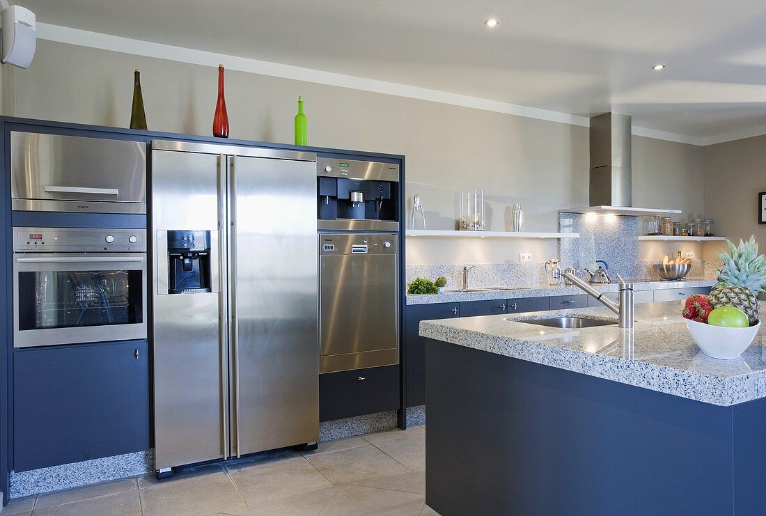 Grosser Edelstahl-Kühlschrank mit Gefrierfach in einer modernen blauen Küche