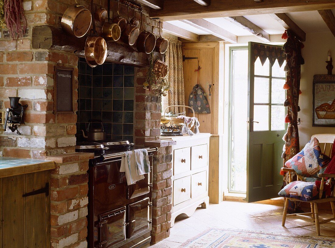 Ein Holzofen in gemauertem Kamin in einer Landhausküche