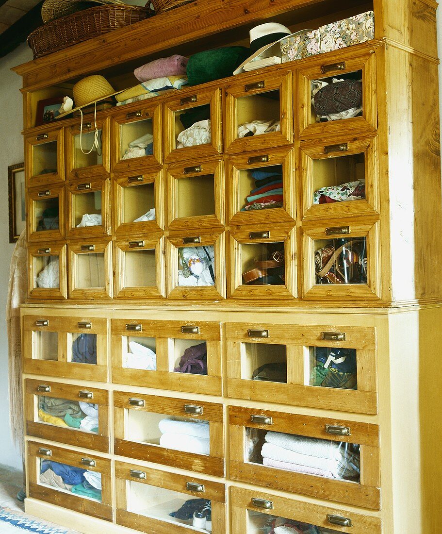 Alter Kleiderschrank aus Holz, die einzelnen Fächer mit Glasfronten