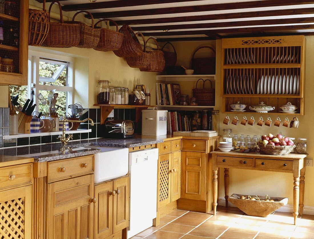 Eine ländliche Küche mit einer Sammlung von Körben an der Decke und einem Tellerhalter
