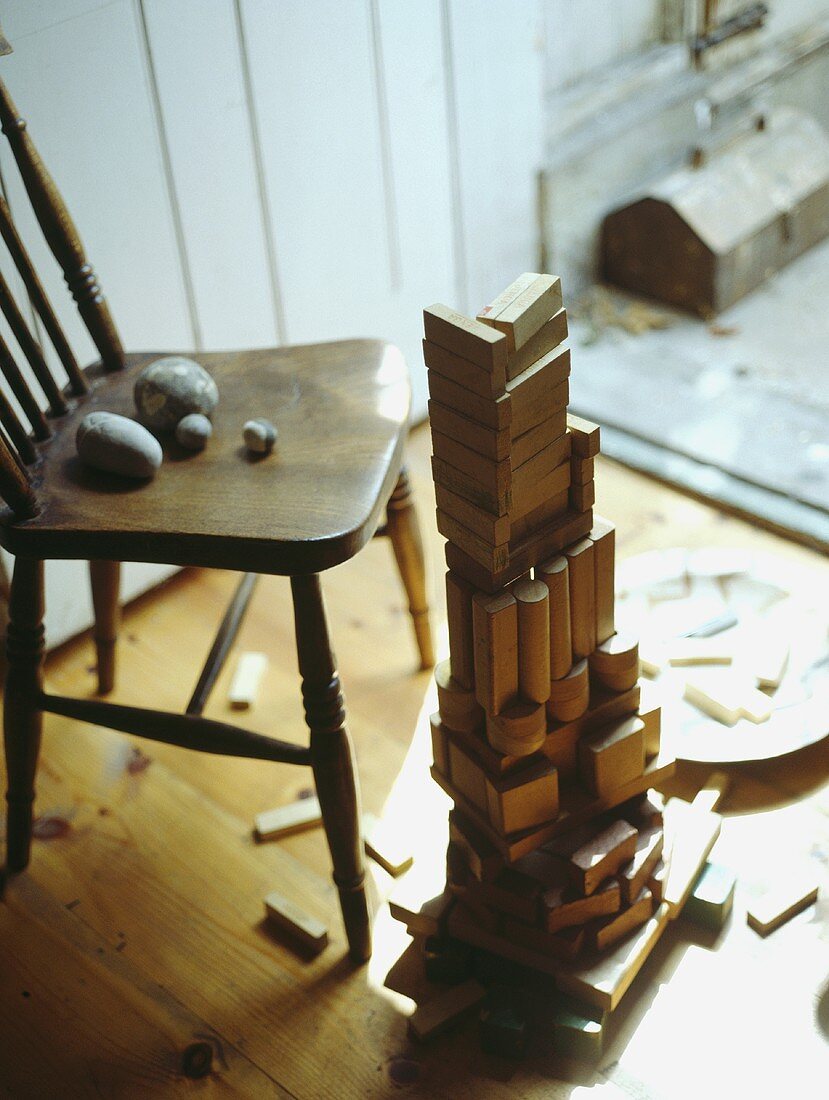 Nahaufnahme eines Holzstuhls und eines Haufen alter Kinder Holzbausteine