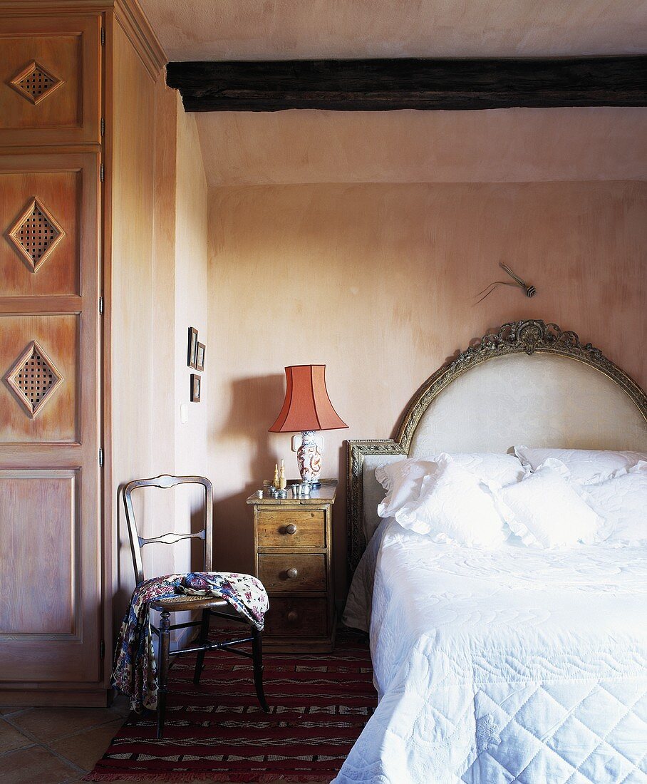 weiße Decken und Kissen auf Einzelbett mit gepolstertem Kopfteil im Spanischen Schlafzimmer mit Rauputzwänden