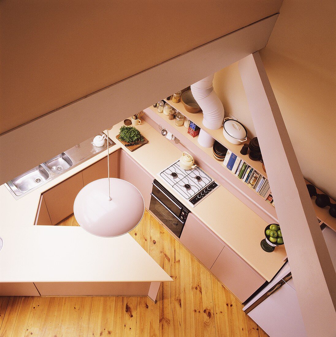 Luftaufnahme einer modernen pastellrosa Küche mit Holzdielenboden