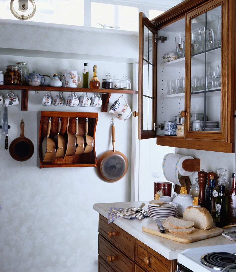 Traditionelle Küche mit aufgehängten Tassen, Töpfen, Pfannen und einfachen Schränken mit Holzfront