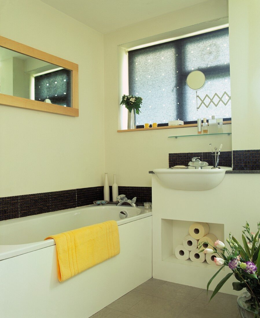 Helles Bad mit schmalem Streifen aus dunkelgrauen Mosaikfliesen und gemauertem Stauraum unter dem Waschbecken