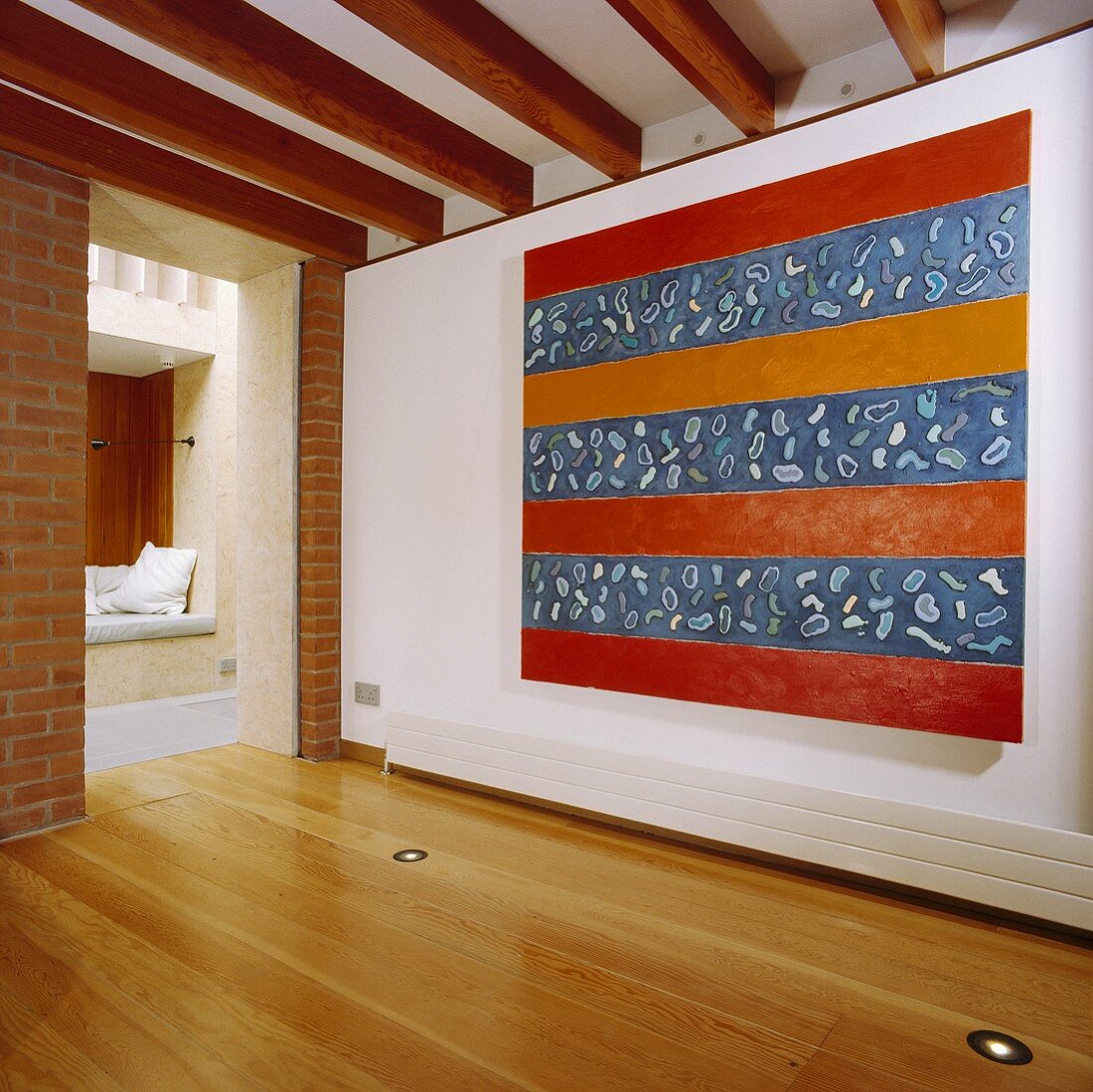 Ein grosses abstraktes Gemälde an der Wand in einem Saal mit Holzbalkendecke und Bodenbeleuchtung