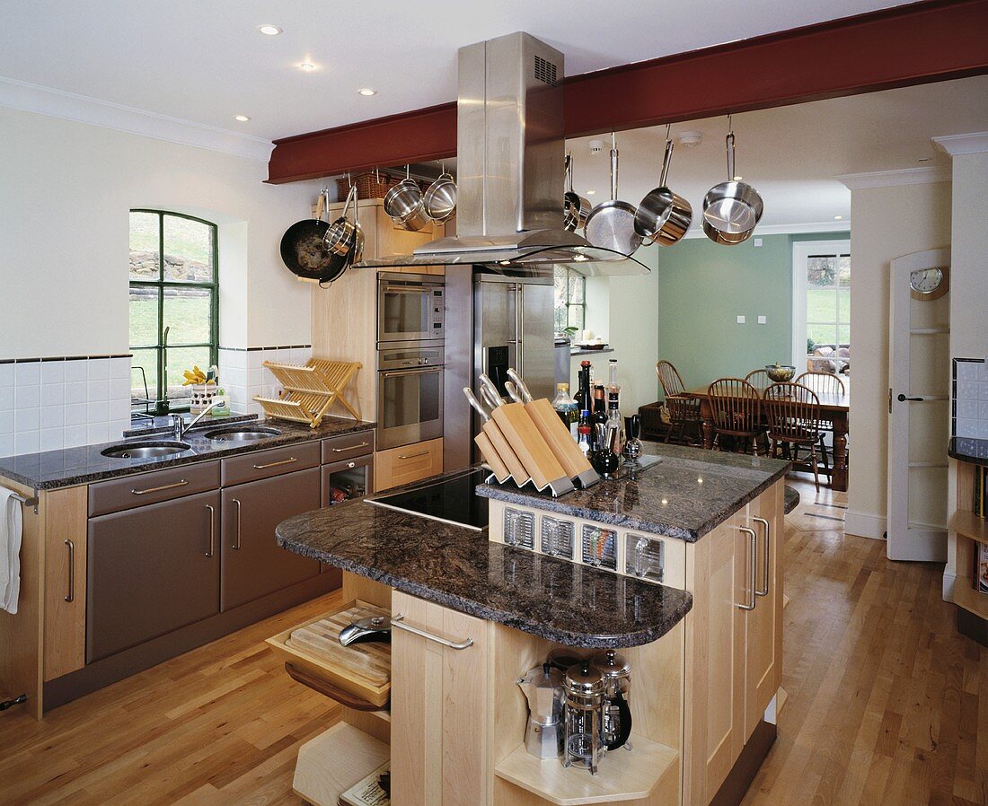 Messerblock auf der Kücheninsel mit schwarzer Granit-Arbeitsplatte in einer modernen Küche mit Parkettboden