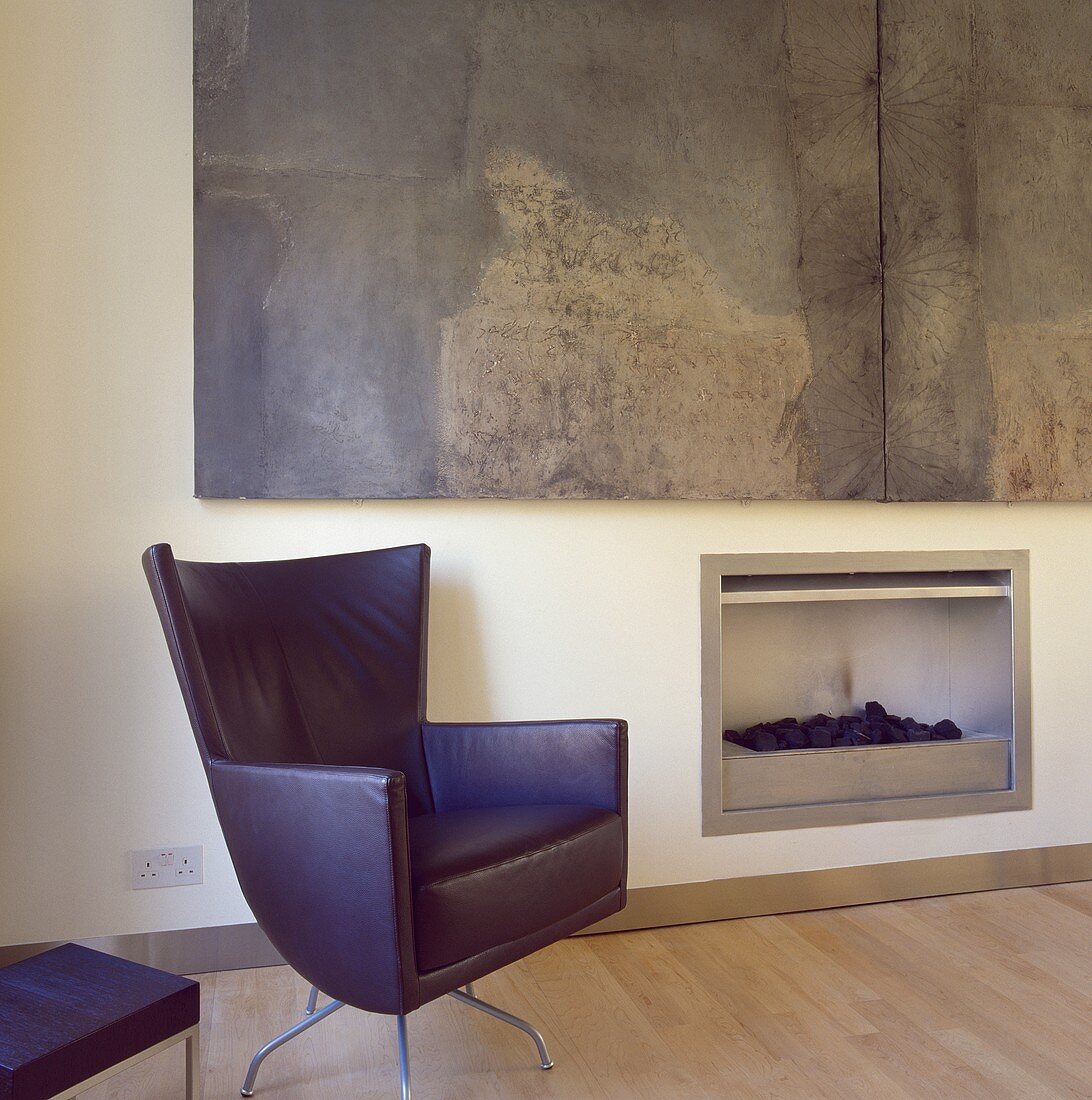 Montis Drehsessel mit Lederbezug neben dem Kamin in einem modernen Wohnzimmer mit großen abstrakten Malerei von Hannah Biggs