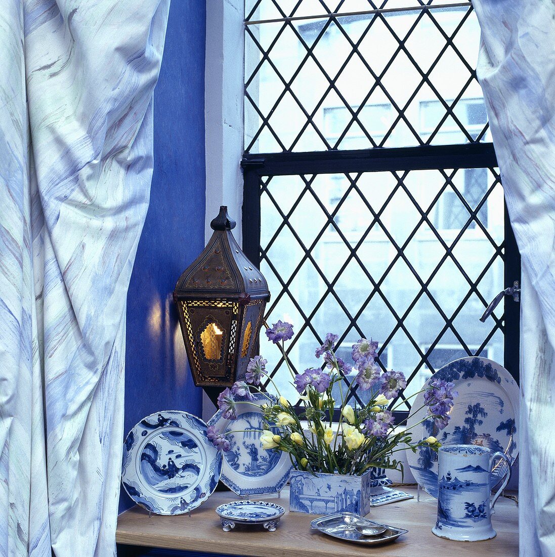 Nahaufnahme von blau-weißem Porzellan auf einer Fensterbank