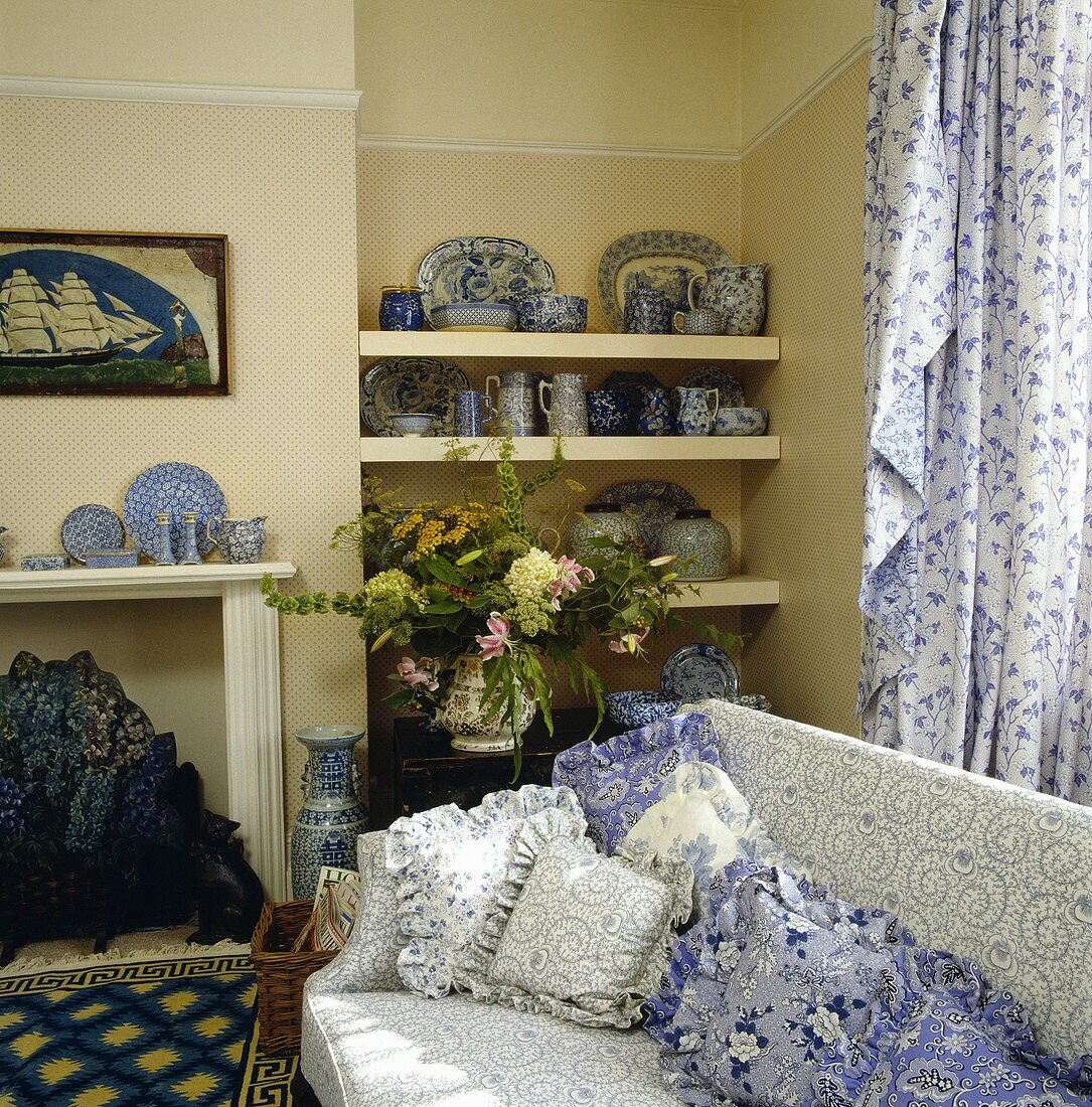 Traditionelles Wohnzimmer mit blau-weiss gemustertem Sofa und dazu passenden Kissen
