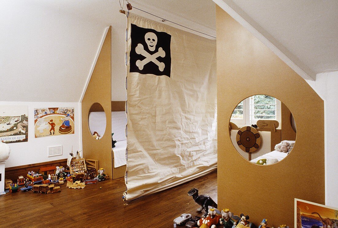 Kinderzimmer mit zwei Betten, die vom Zimmer durch ausgeschnittenen Sperrholzplatten abgetrennt sind und Canvas mit Totenkopf als Raumteiler