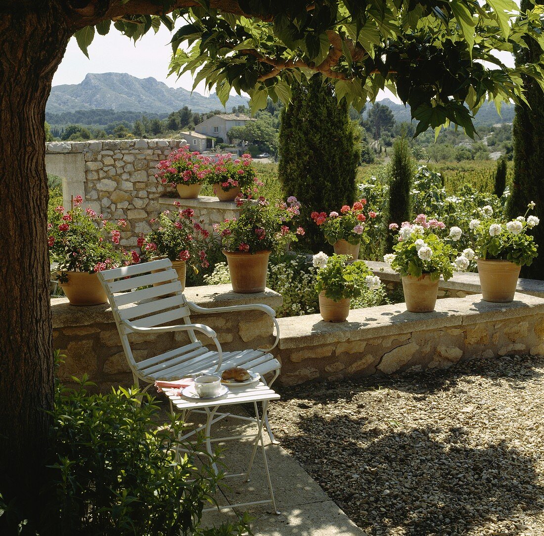 Terrasse mit Geranien und mit Blick auf die umliegende Landschaft in Frankreich