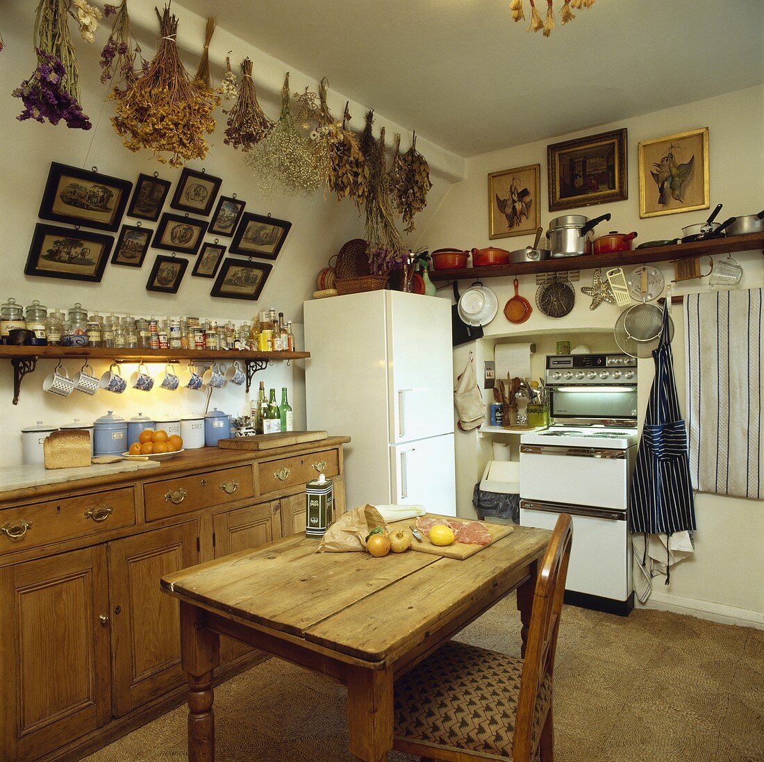 Küche mit Möbeln aus Pinienholz, einem freistehenden Kühlschrank und Elektroherd