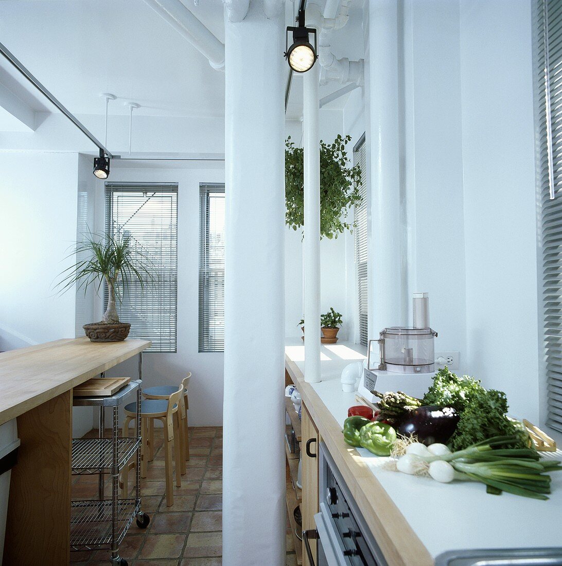 Gemüse auf Worktop in der Moderne weiße Küche mit Frühstücksbar und Spotlichtern