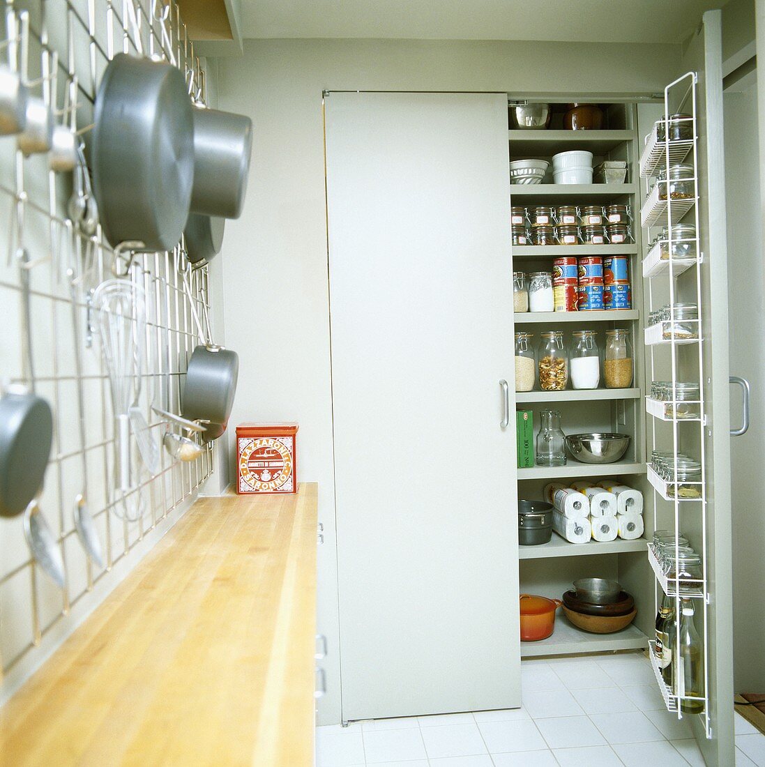 Eingebauter Speisekammerschrank mit geöffneter Tür in einer kompakten Küche