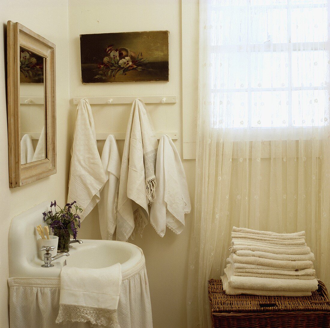 Kleines Waschbecken mit Vorhang und Handtücher in einem ländlichen Badezimmer