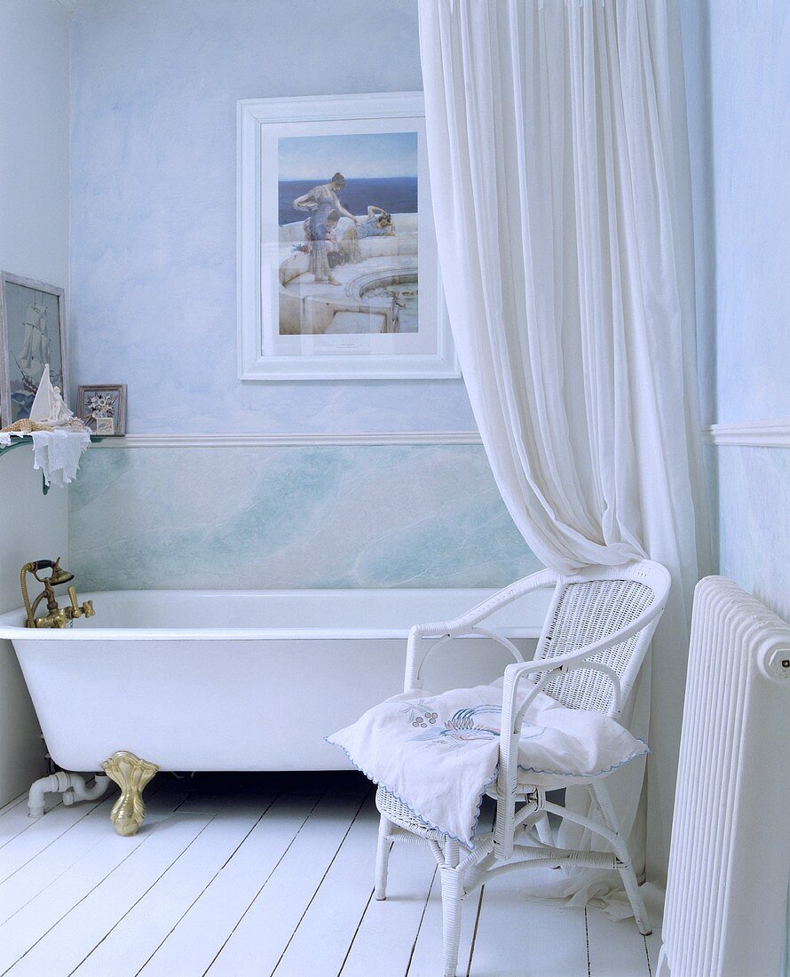 Hellblaues Badezimmer mit weißem Duschvorhang vor der Badewanne