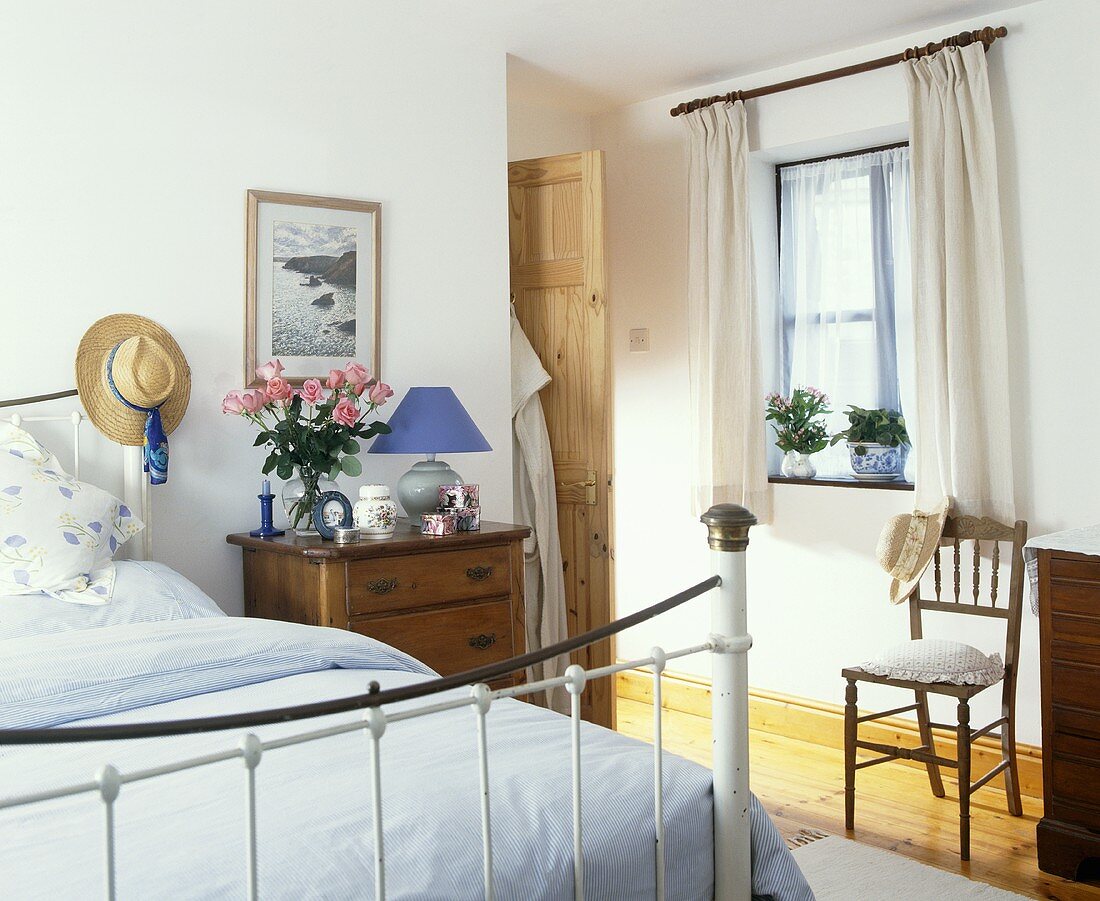 Weisses Messing-Bett mit weißer Bettwäsche im traditionellen Schlafzimmer