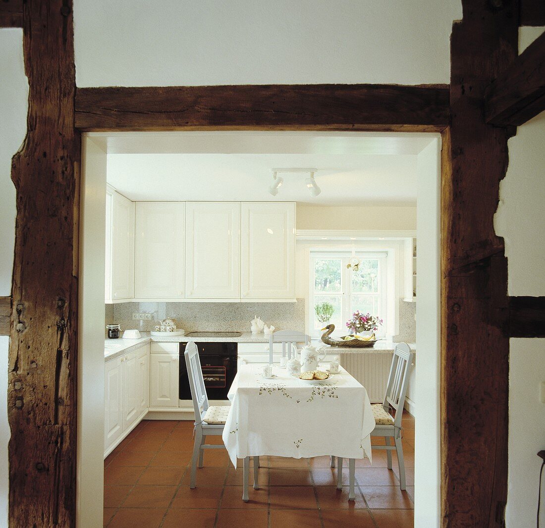 Blick durch Holzrahmen in eine Küche mit Esstisch