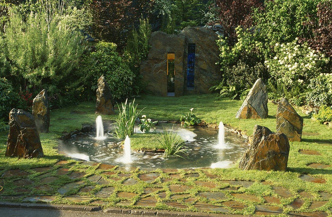 Teich mit Wasserspielen und Felsblöcke im Garten