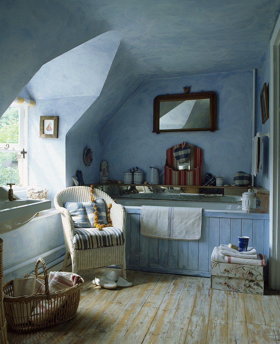 Traditionelles blau getünchtes Badezimmer unter dem Dach mit Holzdielen