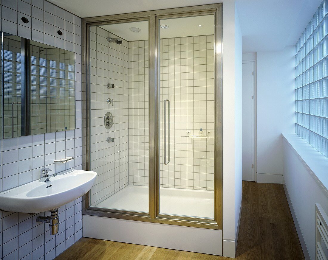 A bathroom with a closed shower cubicle and a glass door