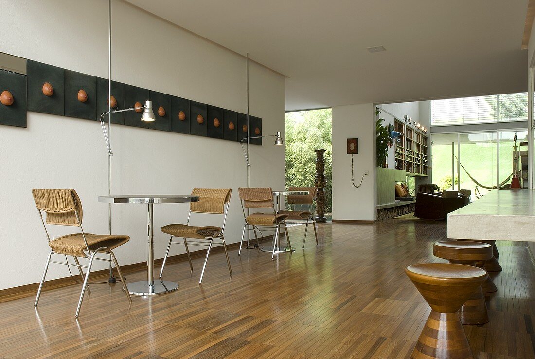 Offener moderner Wohnraum mit Bistrotischen und Stühlen auf Parkett im Neubauhaus