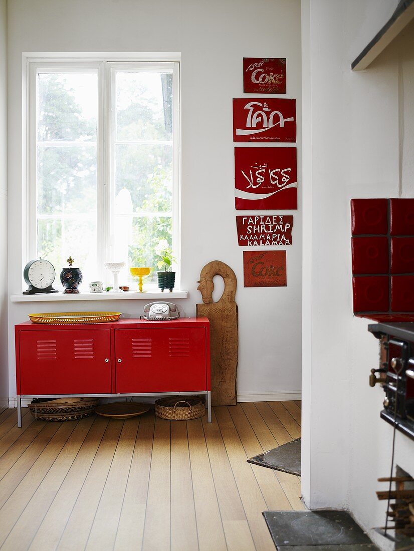 A simple red metal cupboard under a window