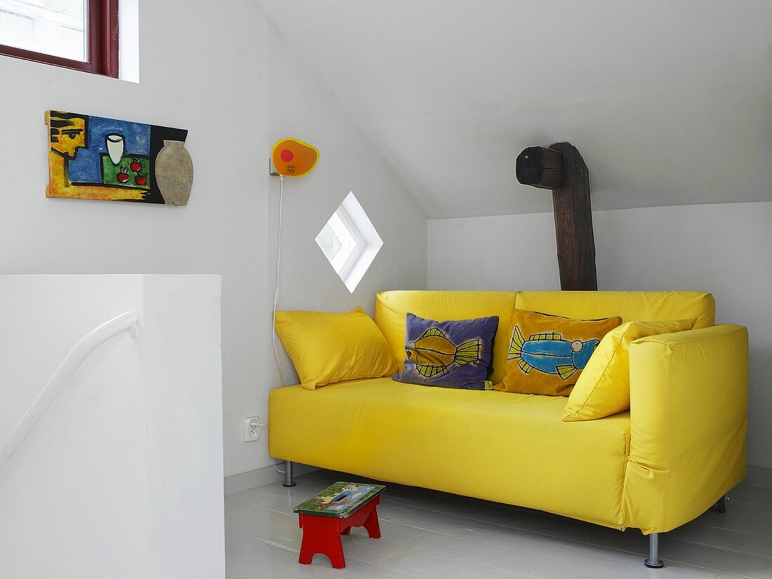 Eine gelbe Couch im Dachgeschoss