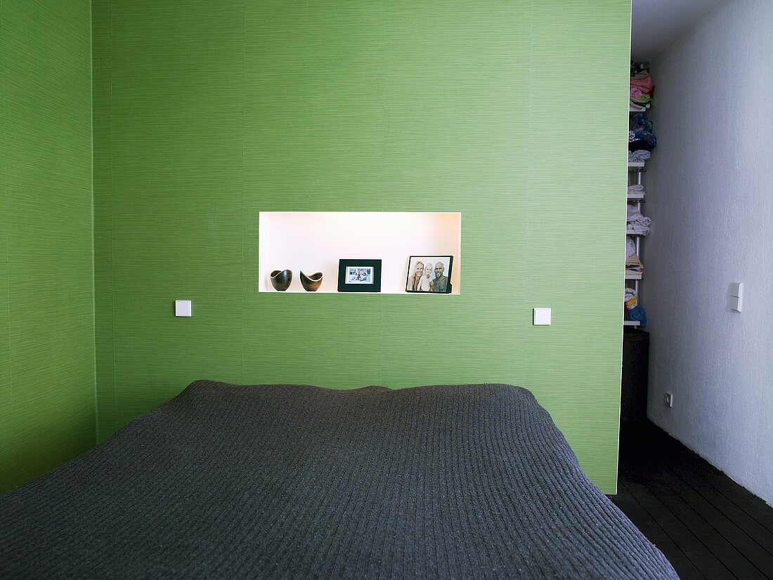 A double bed in a bedroom with green walls