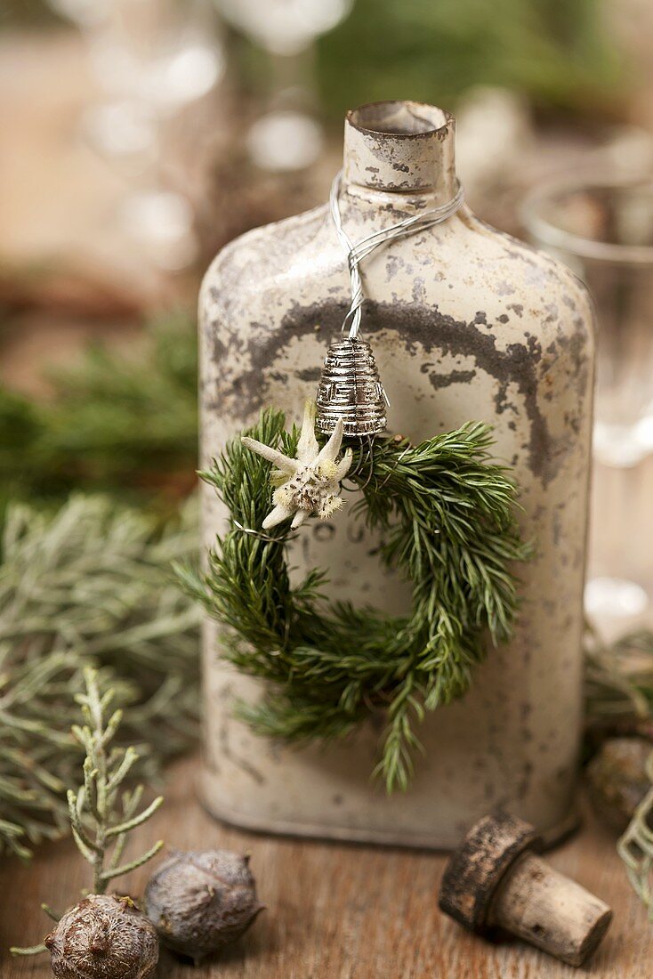 An old hip flask hung with a wreath of rosemary and edelweiss