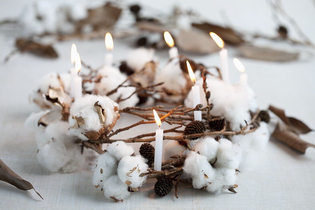 A wintry wreath made of cotton, cones and a candle