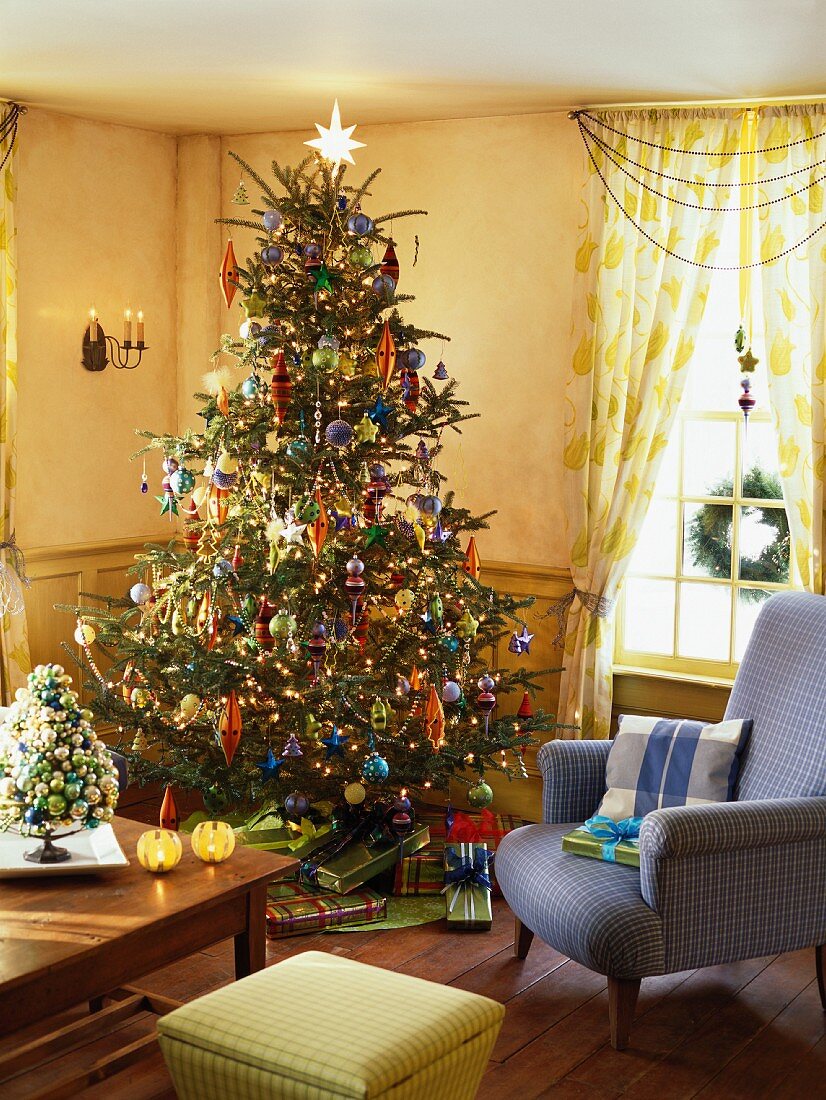Reich geschmückter Christbaum und Geschenke in einem Wohnzimmer