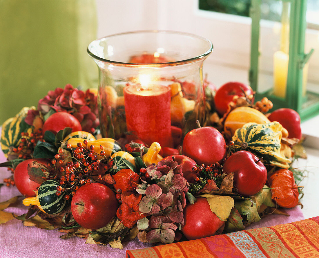 Herbstlicher Kranz um Glas mit roter Kerze