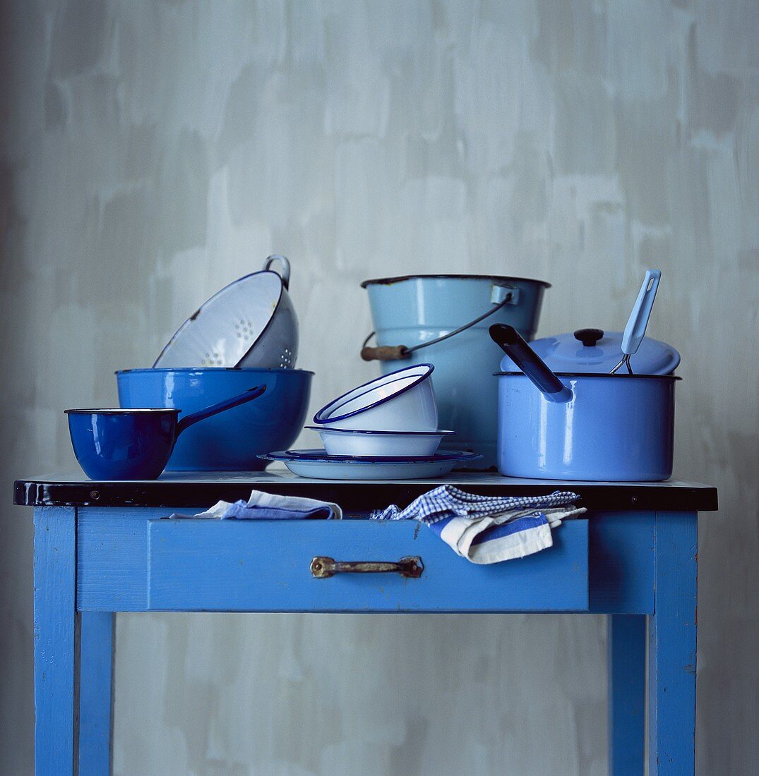 Blauer Küchentisch mit verschiedenen emaillierten Töpfen