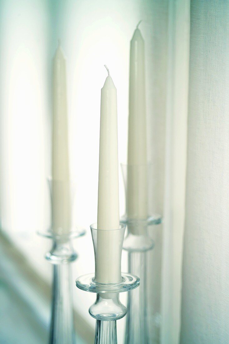 weiße Kerzen in Kerzenständern aus Glas