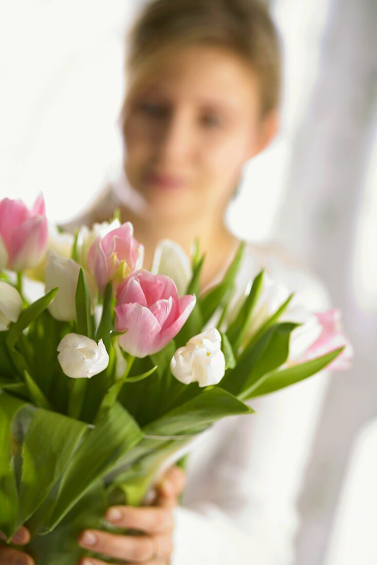 Woman holding vase of tulips