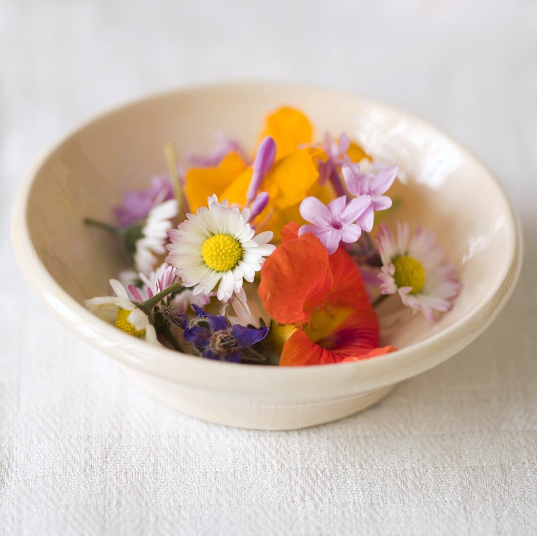 Assorted edible flowers in a ceramic dish