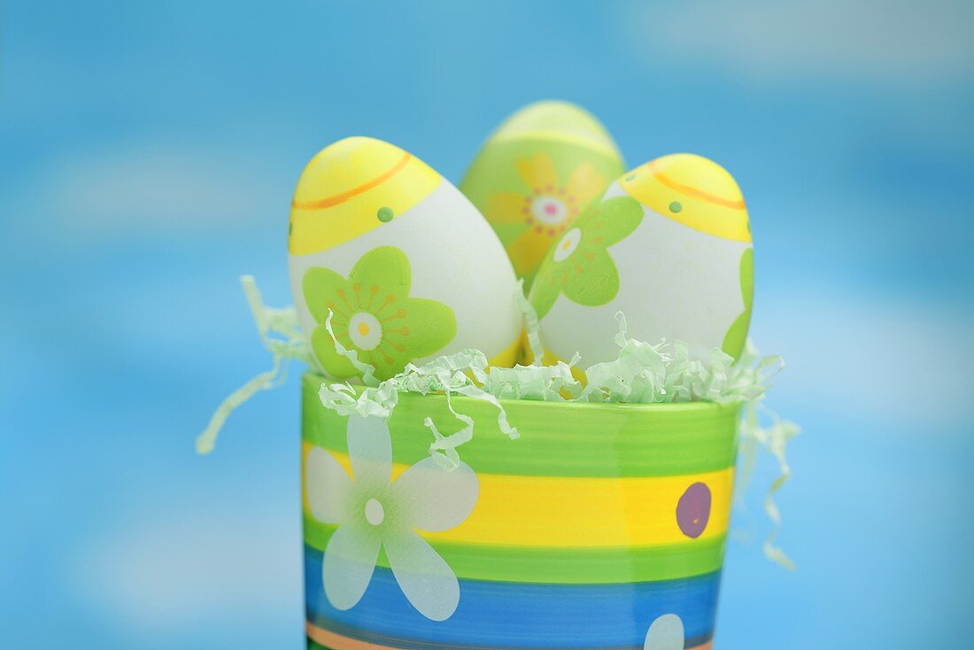 Painted Easter eggs in colourful pot