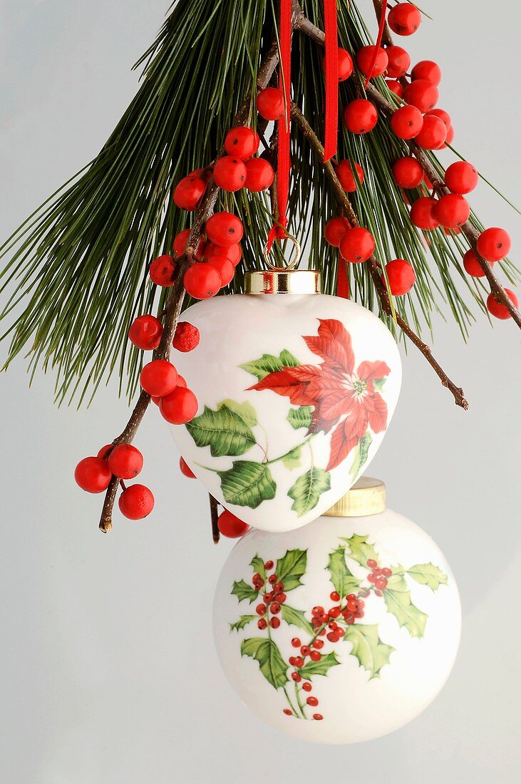 Christmas tree ornaments with holly and poinsettia motifs