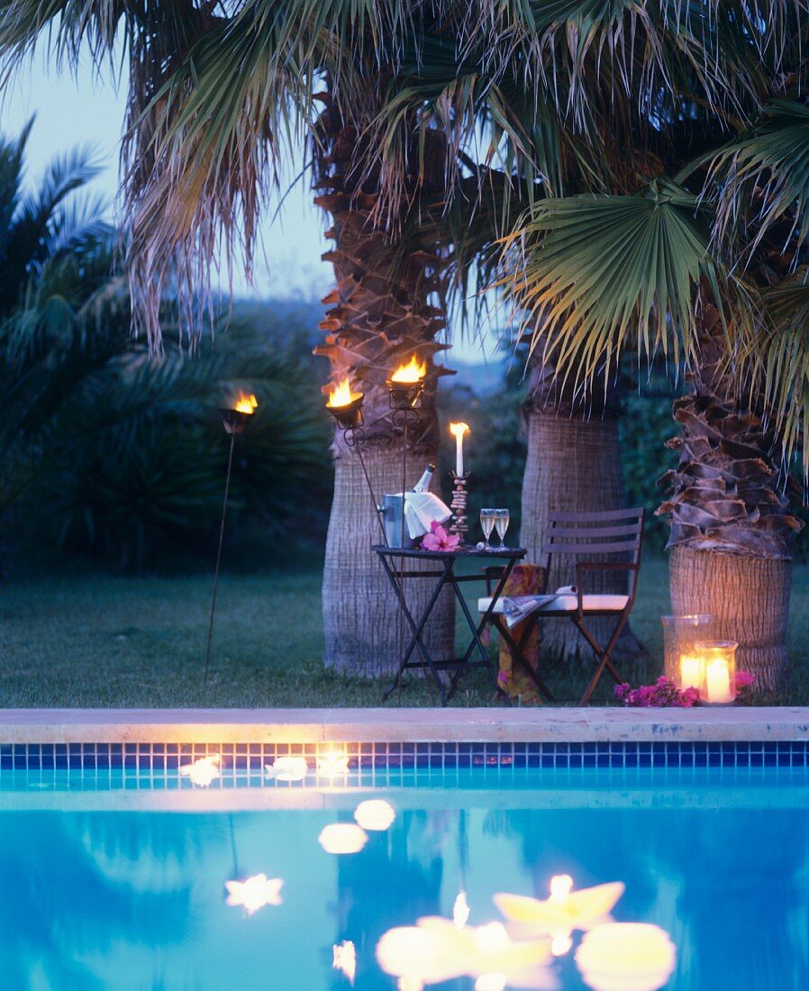 Champagne by candlelight under palm trees by the pool