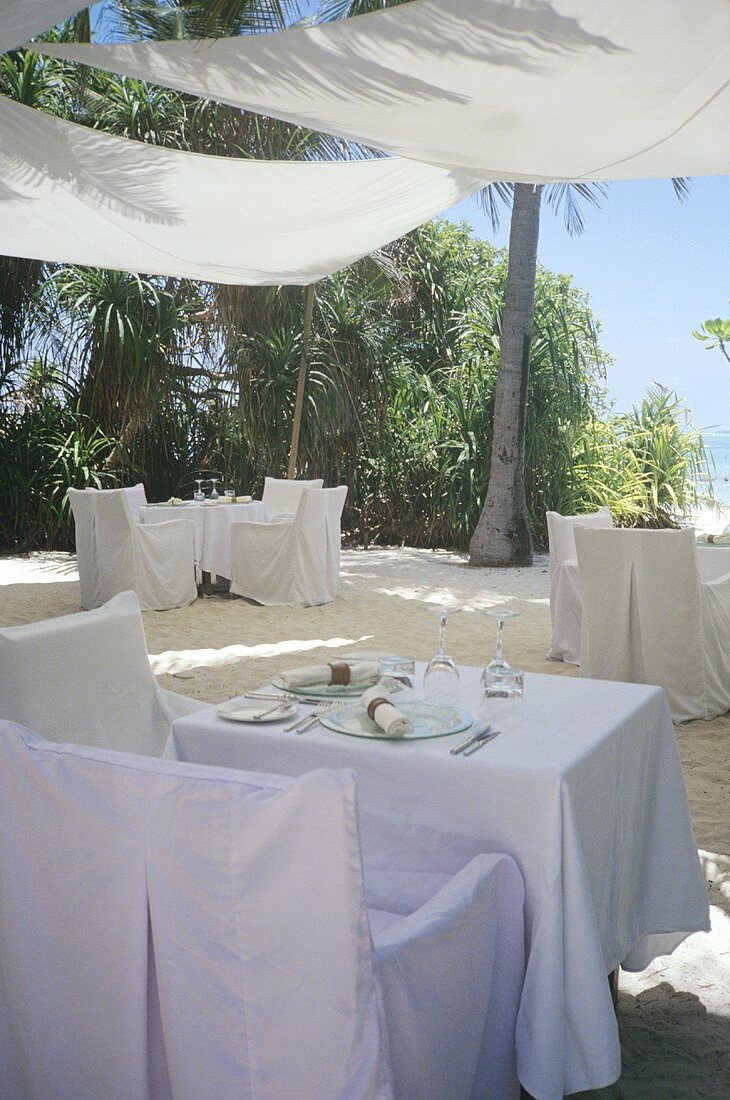 Tables laid in white on the terrace of a restaurant